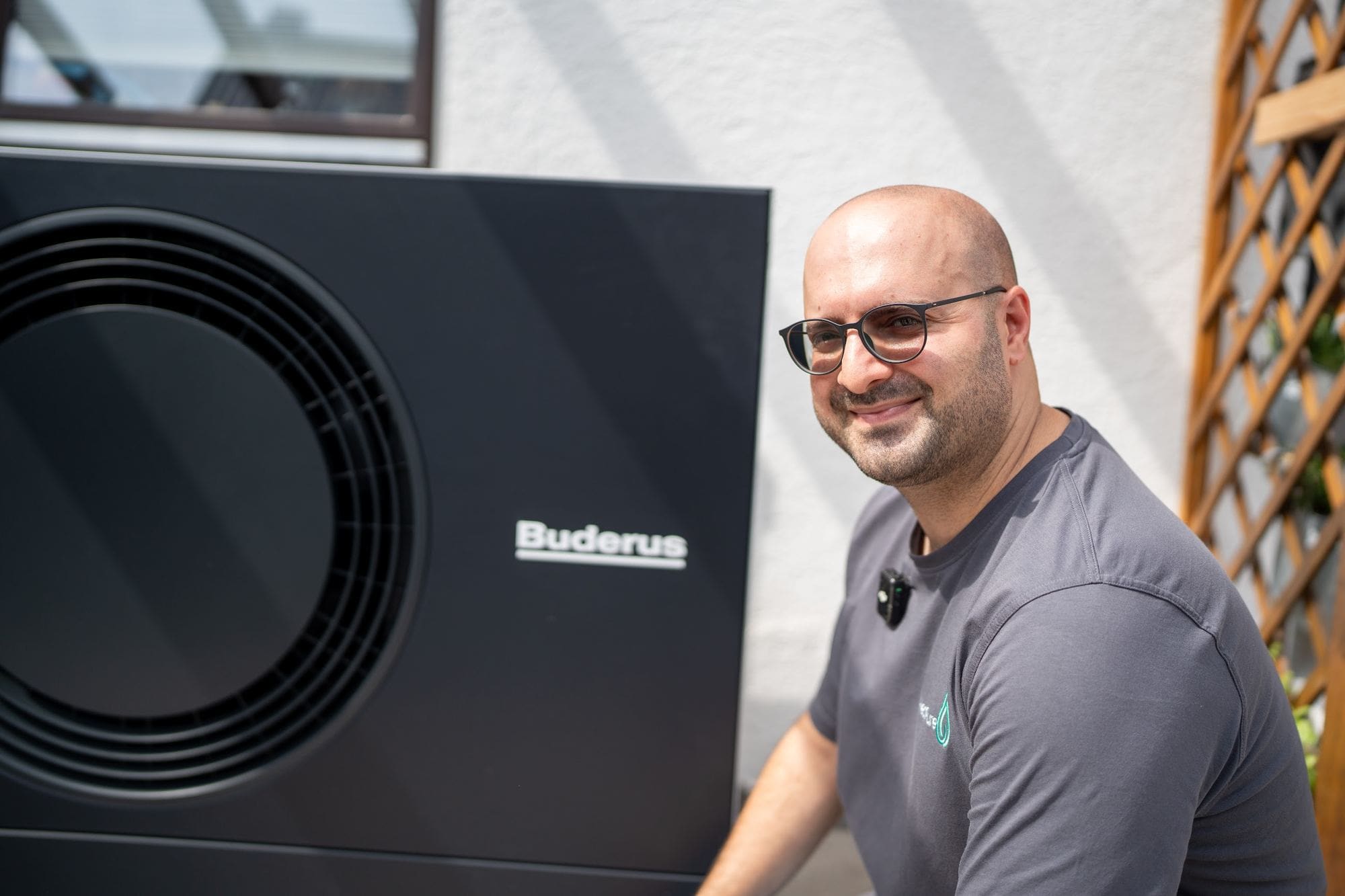 Durmus Pekel von HeatPure neben einer frisch installierten Buderus-Wärmepumpe