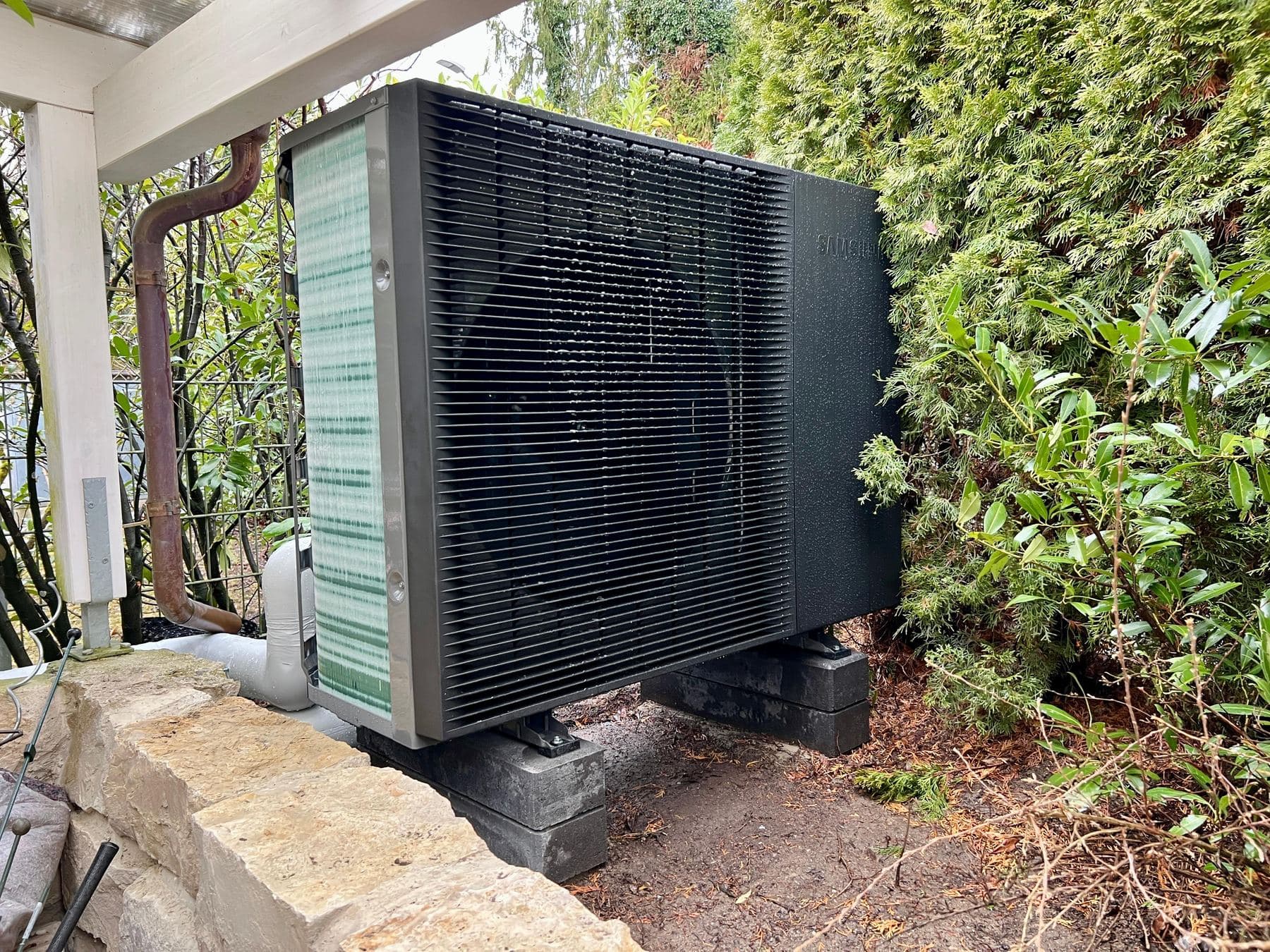 Samsung-Wärmepumpe vor einer Hecke