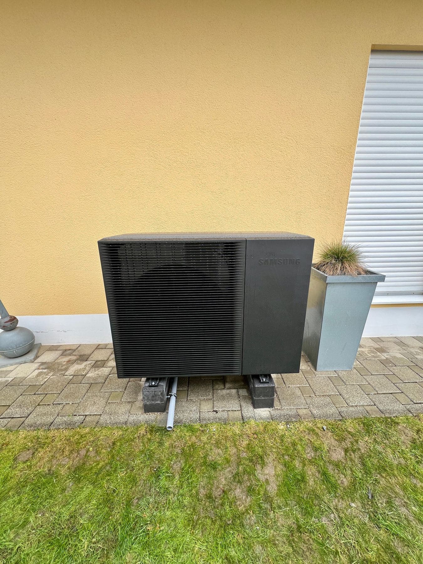 Samsung-Wärmepumpe vor einer gelben Hauswand