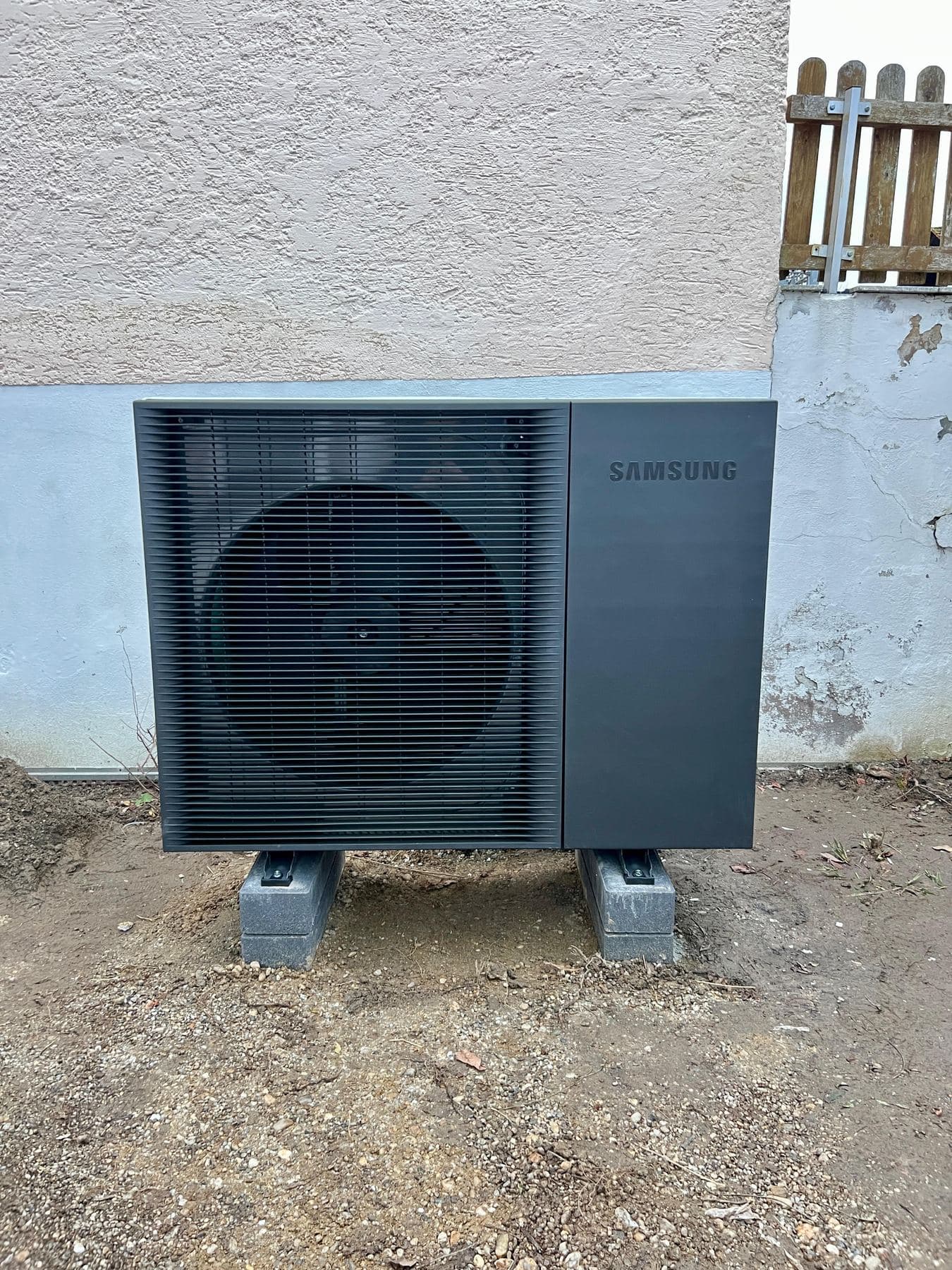 Samsung-Wärmepumpe vor einem Bestandshaus von 1968