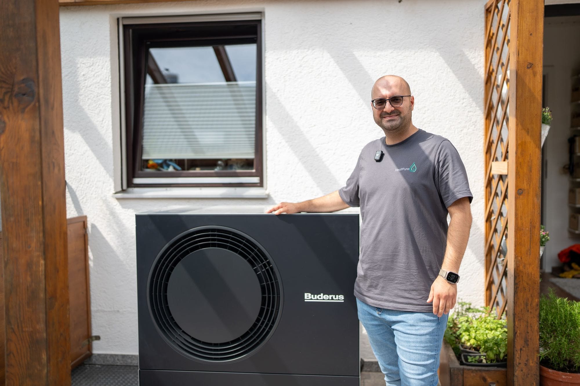 Durmus Pekel von HeatPure neben einer installierten Buderus-Wärmepumpe